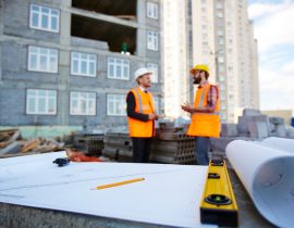 Workplace of builder with sketch in blueprint, level and pencil